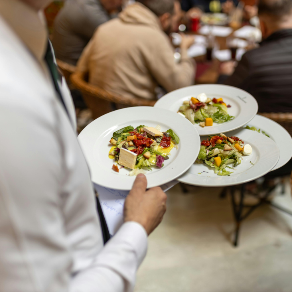 Servicio de restaurante. Camarero con varios platos